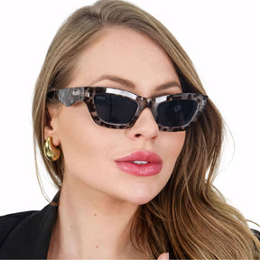 Óculos de sol feminino retrô com armação robusta em acetato italiano. Lentes de policarbonato UV400, detalhes em metal anticorrosivo e design sofisticado para um visual marcante e atemporal.