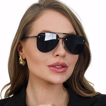 Óculos de Sol Feminino aviador com armação em acetato italiano preto e metal anticorrosivo. Lentes escuras com proteção UV400, resistentes a riscos, água e suor. Sofisticação e proteção em um acessório premium.